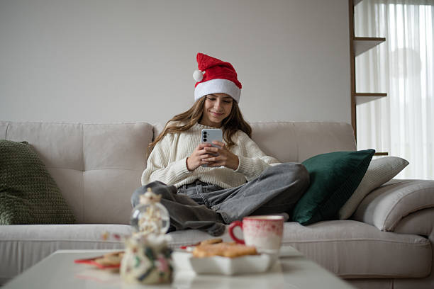 istock Girl with Santa hat using phone 2241554797