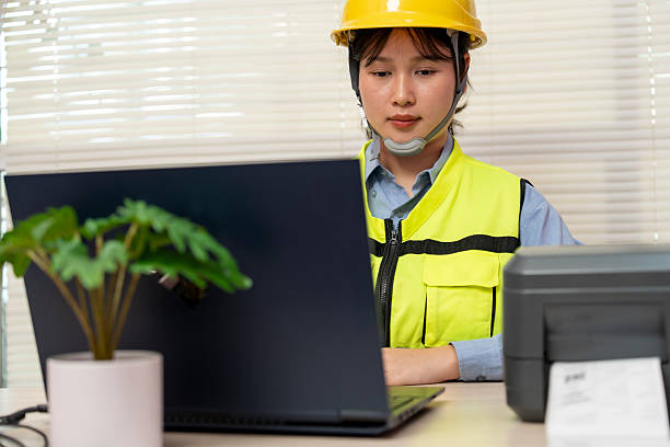 istock Asian female engineer uses a laptop or notebook to print barcode stickers on a barcode printer. 2241554888