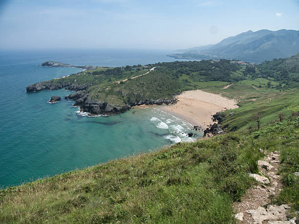 istock Cantabrian Coast Beach and Green Cliffs - High-angle view of a secluded sandy cove and turquoise water, framed by lush green coastal cliffs and mountains along the beautiful Cantabrian Sea. 2241556564