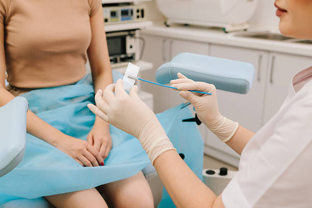 istock Cervical cells are applied to a microscope slide for examination. A Pap smear sample on a slide for testing. Gynecologist prepares a cytology slide using a sterile brush. 2241556680