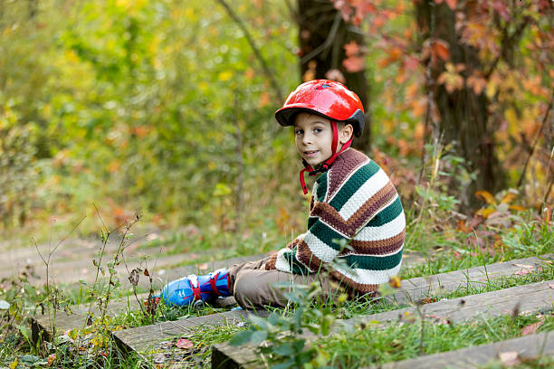 Cute school child, boy, riding roller skates, skating on the street autumntime