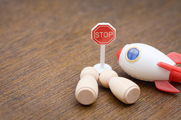 A poignant image featuring a STOP sign next to a toy rocket and fallen figures, symbolizing the urgent need to halt war and prevent human casualties.