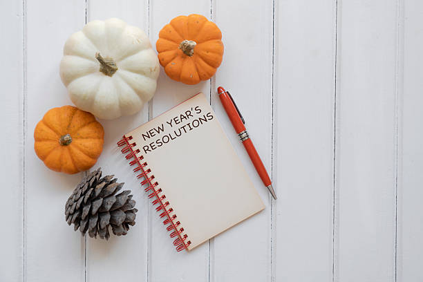 istock Hello autumn concept.Pumpkins and a blank notepad on a wooden background 2241559012