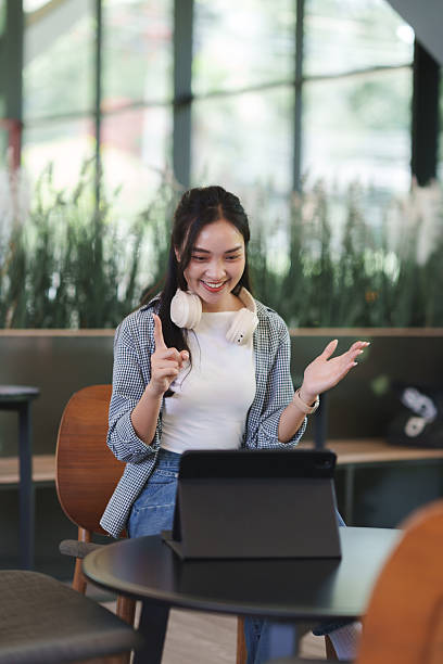 istock Woman having video call using tablet in cafe 2241560263