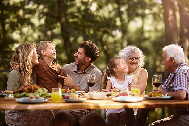 istock Cheerful extended family having fun during lunch at picnic table. 2241562231