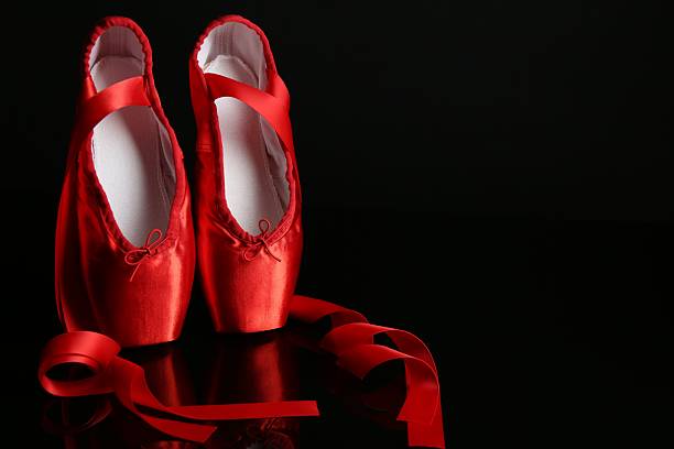 istock Pair of beautiful pointe shoes on black mirror surface. Space for text 2241562547