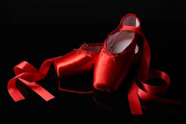 Pair of beautiful pointe shoes on black mirror surface