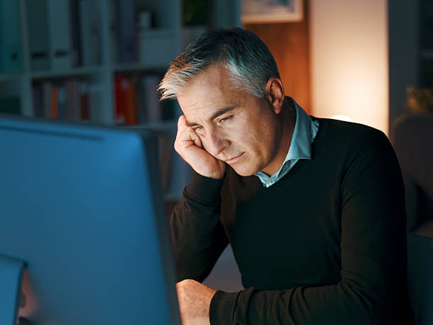 istock Tired businessman working late at night 2241562781