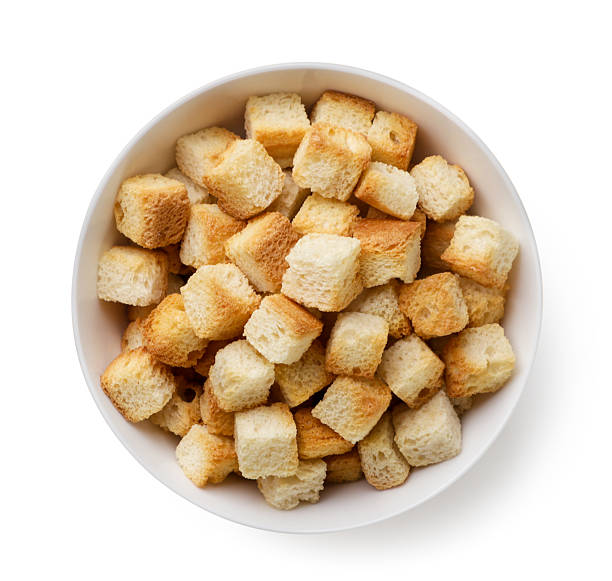 istock Bread croutons in a plate on a white. Top view 2241565120