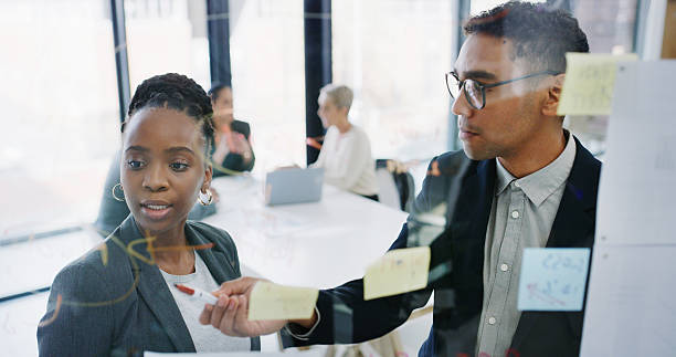 istock Team, planning and people with strategy, glass and sticky notes for proposal and financial analysis. Business analyst, talking or discussion for risk assessment, man and meeting with woman in office 2241566746