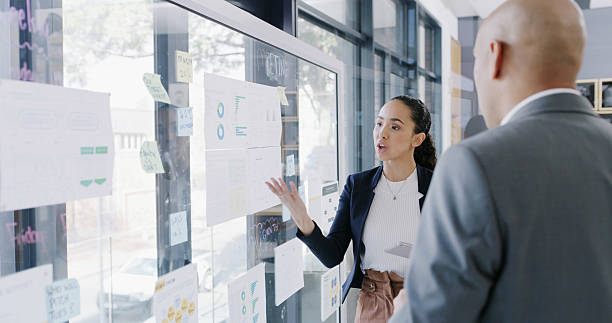 istock Brainstorming, team and people with data analysis, glass and graphs for proposal or risk assessment. Business analyst, charts or strategy with sticky notes, man and collaboration with woman in office 2241566789