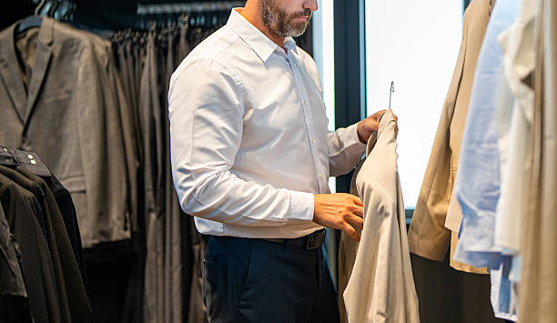 istock Trendy suit jacket. Hispanic businessman choosing tailoring. Bespoke tailoring. Male model in suit boutique. Retail assistant help stylish man to find suit. Stylish man in suit, cropped view 2241568921