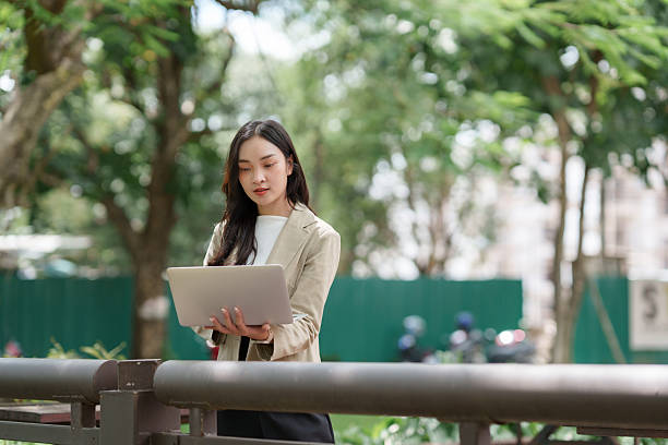 istock Woman working remotely with laptop in park 2241569038