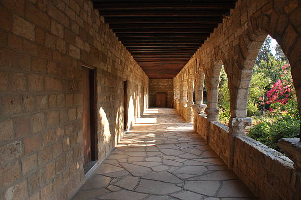istock Sunlight filters through arches in a stone corridor surrounded by vibrant nature 2241570176