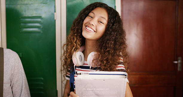istock Student, girl and portrait with book in high school for learning, education and ready for class. Scholarship, teenager and smile in hallway for knowledge, academic development and study opportunity 2241574321