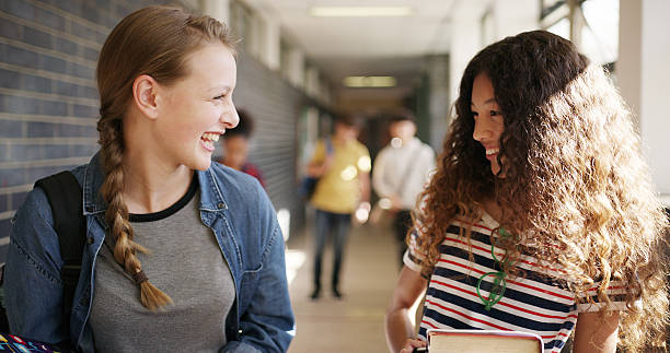 istock Laugh, walking and friends at high school in hallway for learning, lesson and education together. Happy, campus and teenagers in conversation, talking and chat in corridor for bonding, relax or break 2241574546