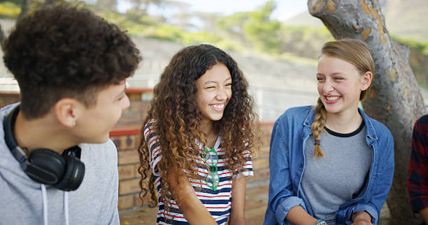 istock High school, break and students outdoor for talking, conversation and chat together on campus. Academy, teenagers and friends laughing for funny story, gossip and discussion at recess for education 2241574639