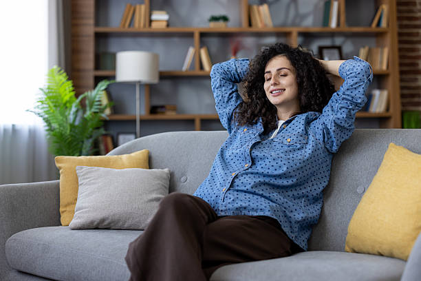istock Serene woman relaxing on comfortable sofa at home 2241575719