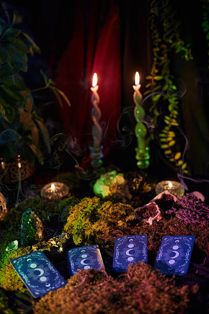 istock Tarot cards rest on a bed of moss, accompanied by flickering candles and plants, creating a serene atmosphere. soft light adds a magical touch to the scene 2241577861