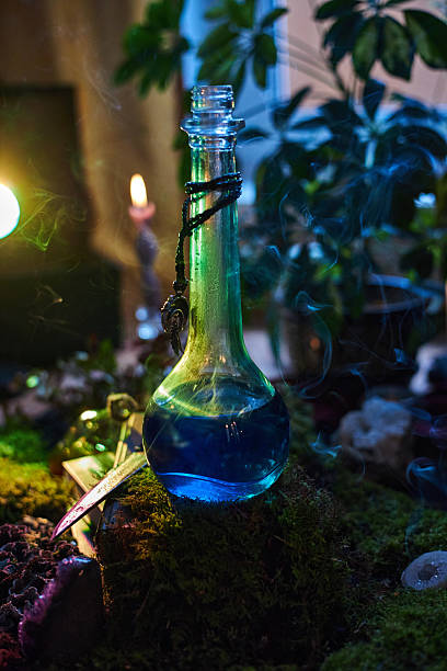 istock captivating glass bottle filled with blue liquid sits on moss. Soft candlelight and greenery create an enchanting atmosphere during the evening hours 2241577877