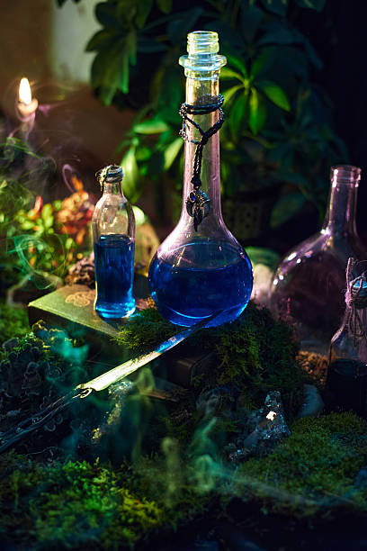 istock Blue potions sit on a table surrounded by vibrant moss and candles. scene is lit with a warm glow, creating a magical atmosphere perfect for potion-making 2241577882