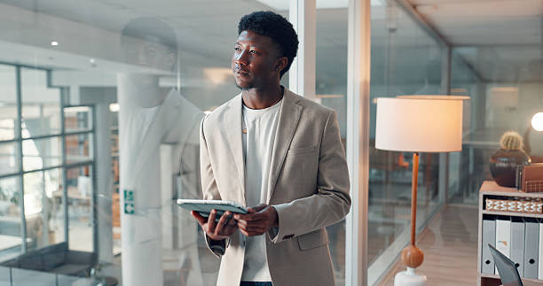 istock Thinking, window and tablet with business black man in office for reflection, article fact check and review. Journalist vision, planning and research with person in news agency for perspective 2241578464