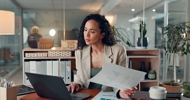 istock Woman, laptop and documents at startup with stats, solution or scroll with info at digital agency. Person, computer and paperwork with insight, graphs or report for social media marketing at company 2241578596