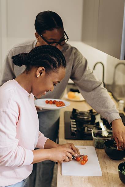 istock Two black women preparing dinner together in modern kitchen 2241579283