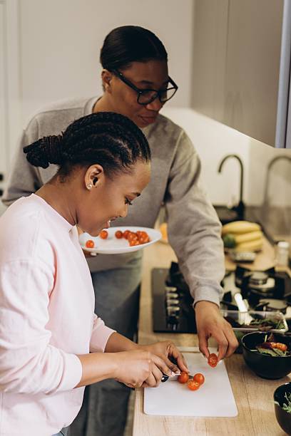 istock Two black women preparing tomatoes in modern kitchen 2241579285