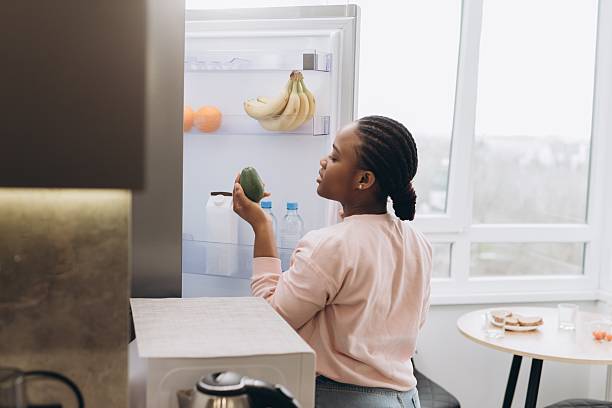 istock Woman choosing avocado from refrigerator at home 2241579348