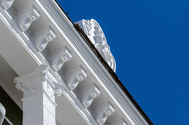 istock Renovated building showcasing elegant white stucco cornice against light green cinder block wall under clear blue sky 2241580920