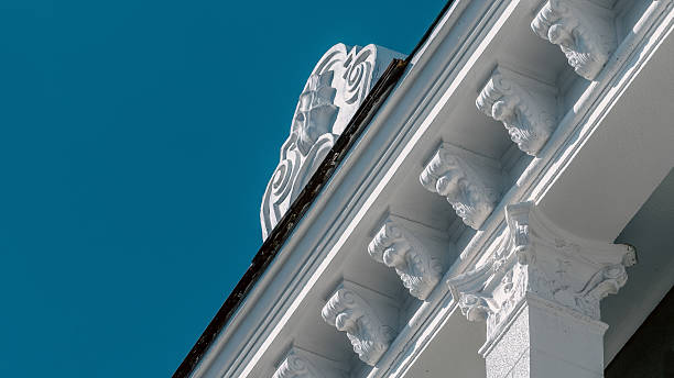 istock Renovated building showcasing elegant white stucco cornice against light green cinder block wall under clear blue sky 2241580924