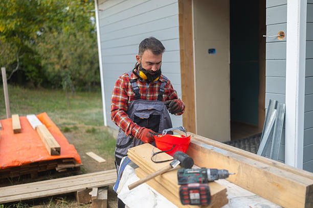 istock Male construction worker building a wooden house under construction outdoors with tools and safety gear 2241581560
