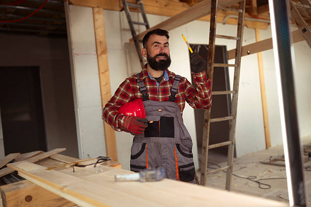istock Male Construction Worker Measuring Wooden House Frame During Construction 2241581610