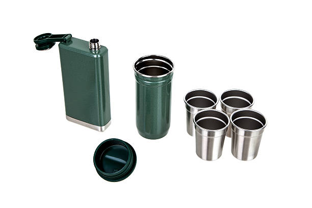 istock Open flask, container, and four shot glasses from a green portable bar set. 2241581939
