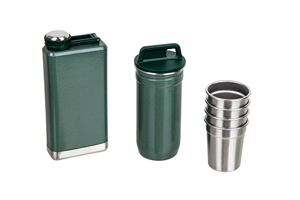 istock Open flask, container, and four shot glasses from a green portable bar set. 2241581942