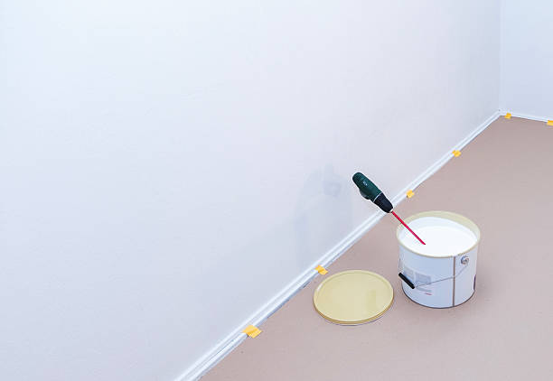 istock A can of paint and a cordless drill with a mixer inside. 2241583479