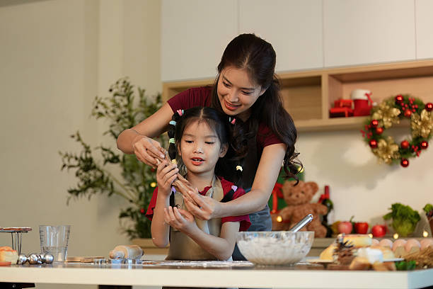 istock Mother and Daughter Baking Cookies Together in a Festive Kitchen 2241584077