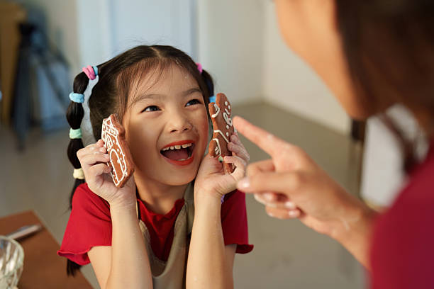 istock Gingerbread Delight. Child joyfully presenting decorated cookies during holiday baking. 2241584286