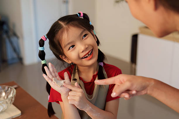 istock Joyful Baking: Young Girl Enjoying Time with Mother 2241584471