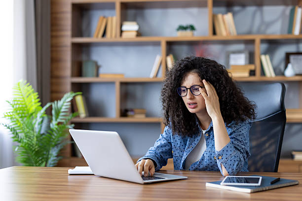 istock Young woman experiencing stress and headache working from home 2241584578