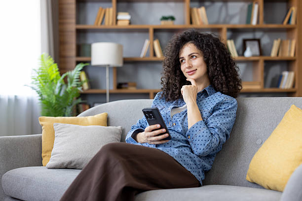 istock Woman relaxing on sofa thinking with phone 2241586491