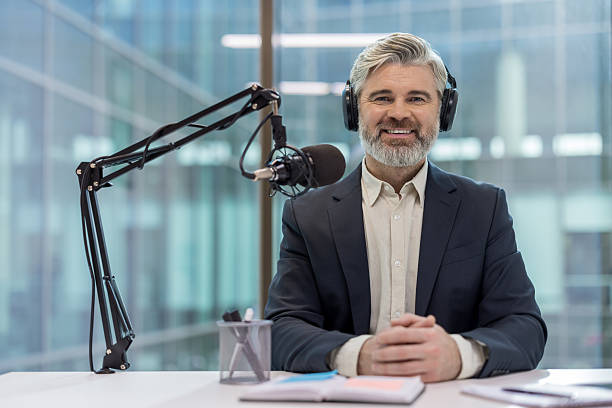 istock Mature man podcasting at office broadcasting an interview 2241587277