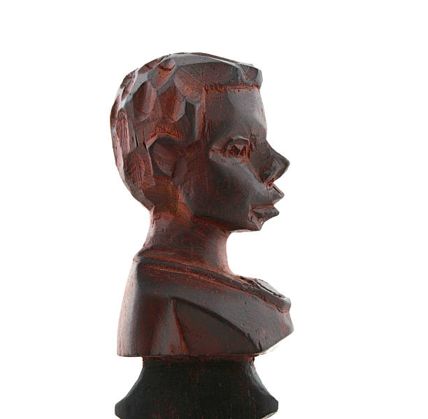 Dark wood carving depicting an African head bust in profile, showcasing traditional folk art craftsmanship and cultural heritage on a white background