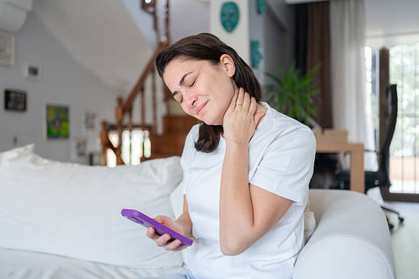 istock Woman Suffering From Neck Pain While Using Smartphone Too Long 2241590327