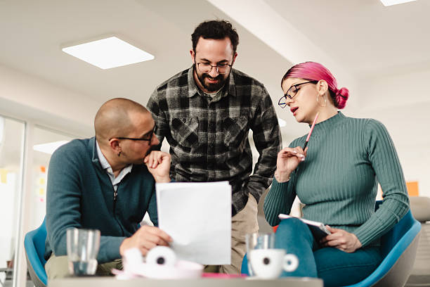 Businesspeople discussing project details in a modern office space during a vibrant brainstorming session