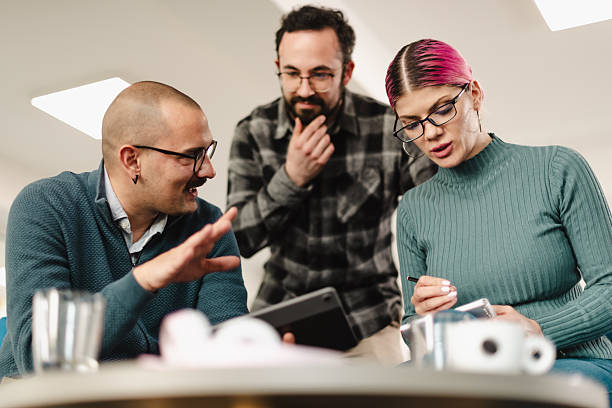 istock Business colleagues collaborating in a modern office setting while discussing plans and analyzing data on a tablet during a team meeting 2241591037