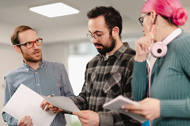 istock Team discussion among businesspeople in modern office setting during afternoon hours while reviewing project documents 2241591378