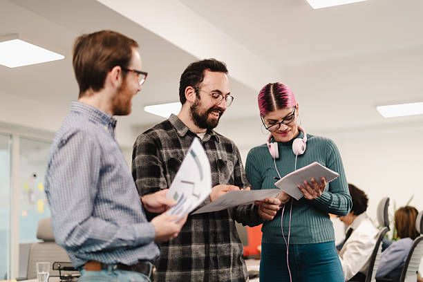 istock Business team collaborates in a modern office space during a meeting while reviewing documents and discussing ideas 2241591392