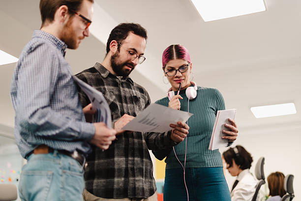 istock Business professionals collaborating on project plans in modern office during daytime meeting 2241591397